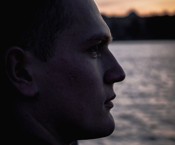 Profile of a man looking thoughtfully towards the horizon.